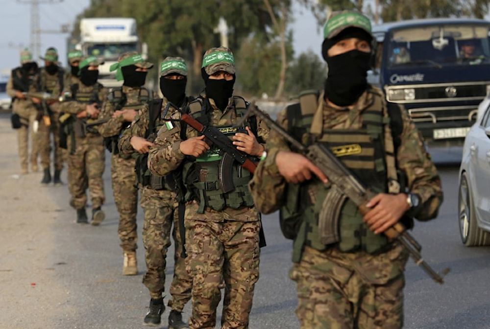 Masked fighters from Al-Qassam Brigades, the military wing of Hamas, march with their weapons along the road of Nusseirat refugee camp, central Gaza, on October 28, 2021.(AP)