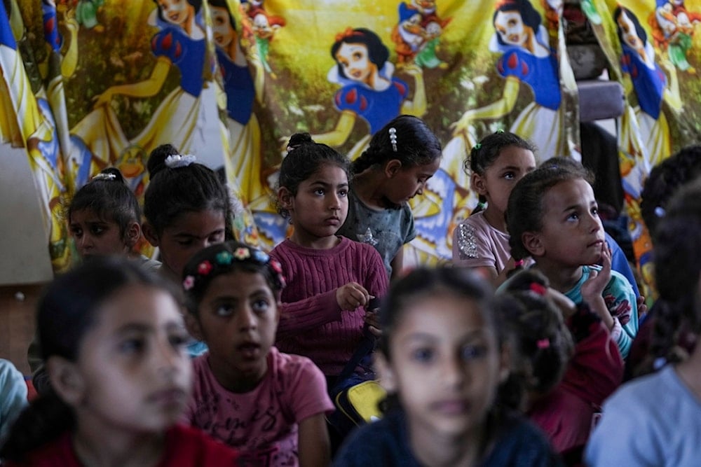 Children attend an activity at a makeshift class in Deir al Balah, on Sunday, April 21, 2024. (AP Photo/Abdel Kareen Hana)