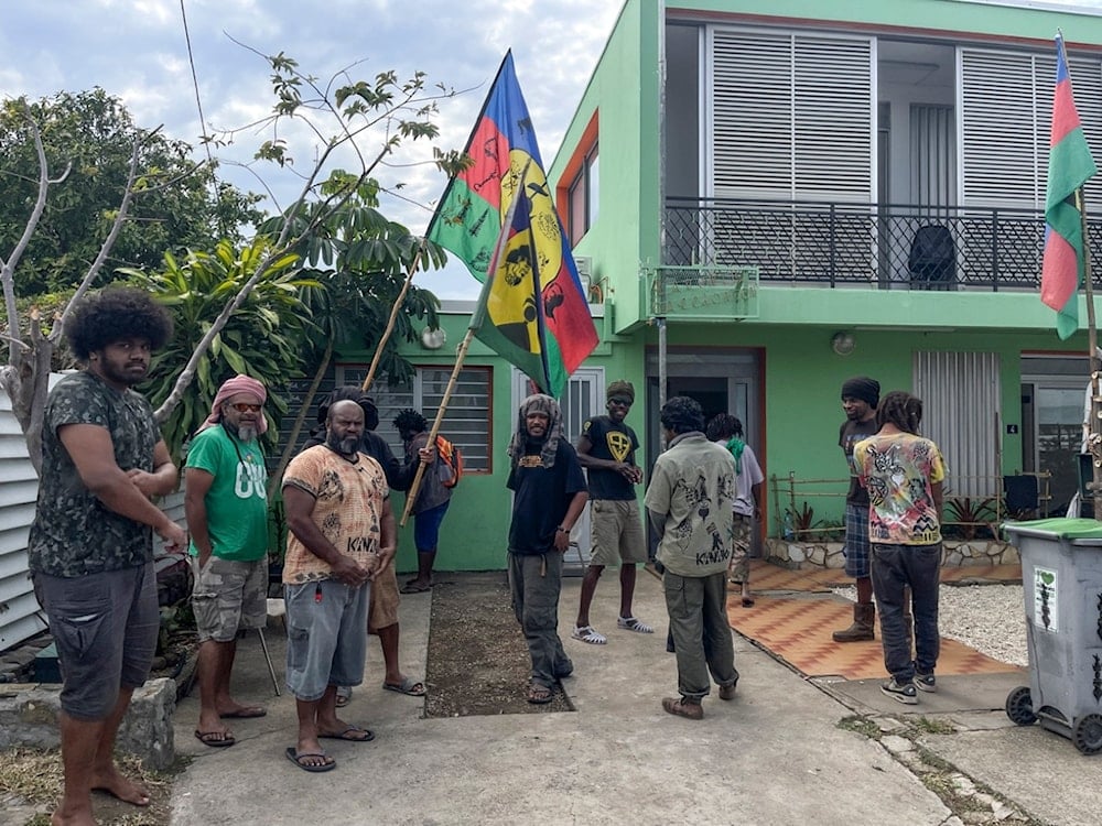 Indigenous Kanaks hold independent flags as they gather near the Field Action Coordination Unit building during the 171st anniversary of France's takeover of the Pacific Archipelago, in Noumea, New Caledonia, Tuesday September 24, 2024 (AP)