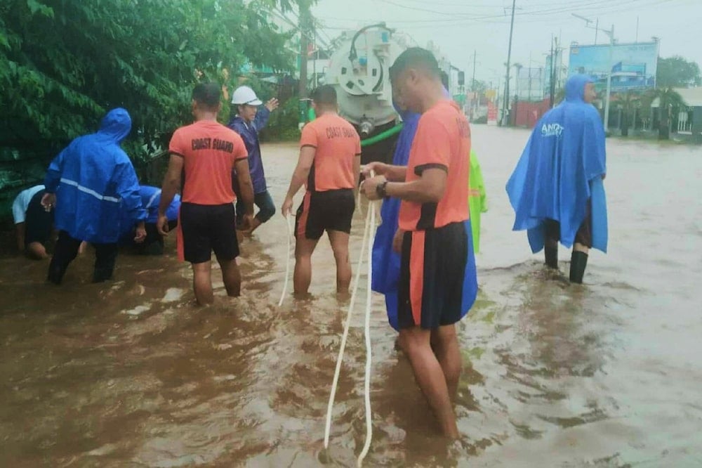 In this photo provided by the Philippine Coast Guard, rescuers inspect a flooded area in Lemery, Batangas province, Philippines caused by Typhoon Matmo on Friday Oct. 3, 2025. (Philippine Coast Guard via AP)