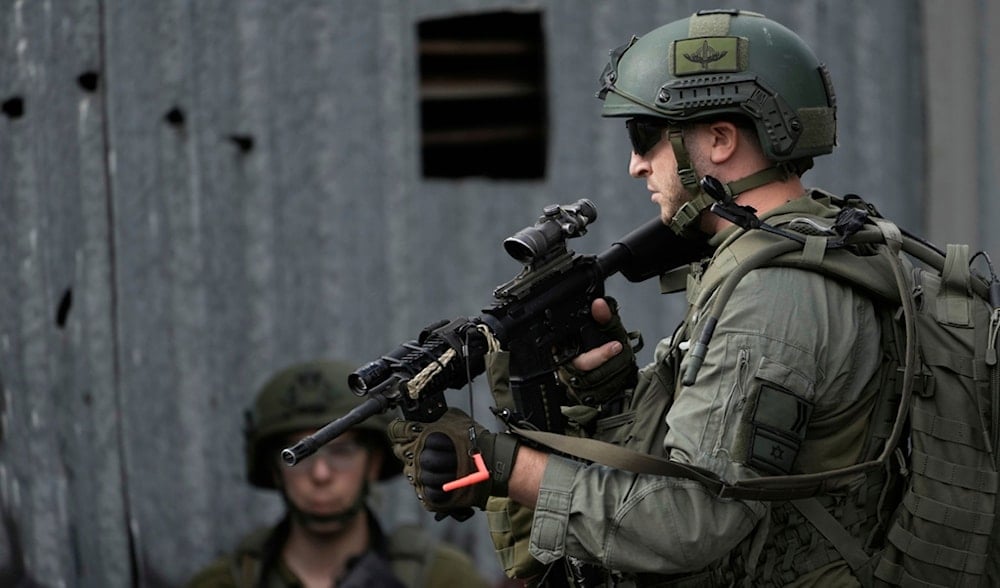 Members of Israeli occupation forces stand in guard on an alley during a military raid in the West Bank city of Nablus, Wednesday, Aug. 27, 2025. (AP)
