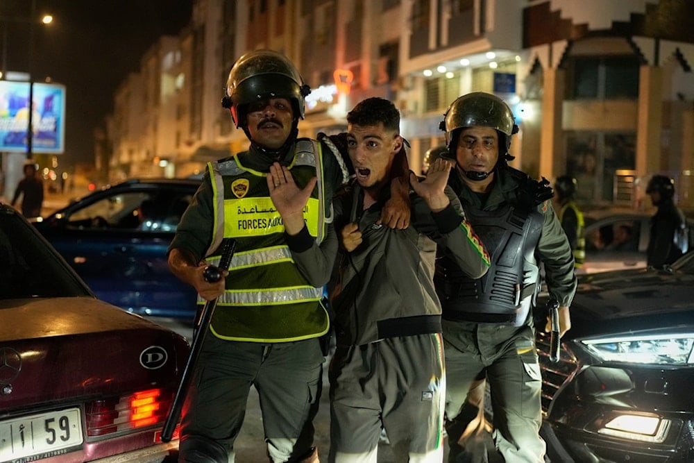 A boy is detained as youth-led protests calling for healthcare and education reforms turned violent, in Sale, Morocco, Wednesday, October 1, 2025 (AP)