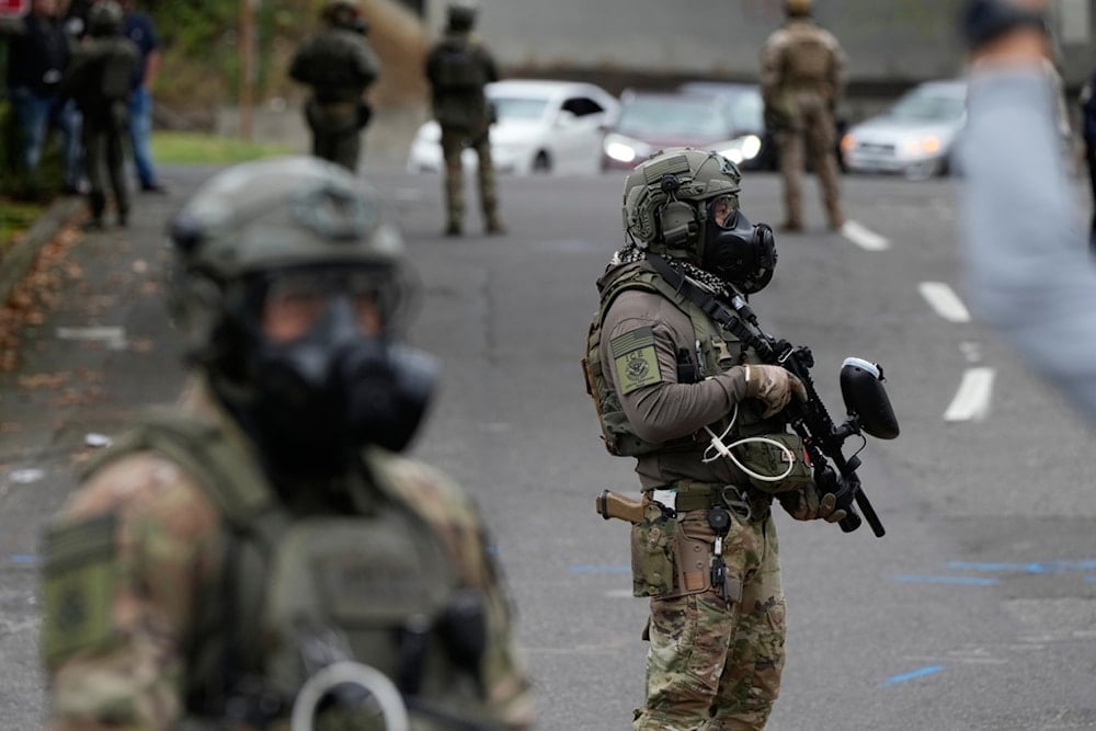 Immigration and Customs Enforcement agents stand outside an ICE facility during a protest on Saturday, October 4, 2025, in Portland, Oregon (AP)