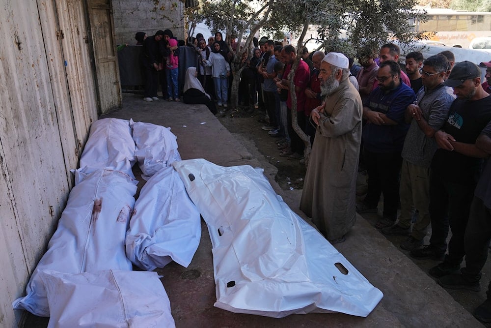 Palestinians pray over the bodies of people who were killed in an Israeli military strike on Sunday, during their funeral at Awda Hospital, in Nuseirat, in the central Gaza Strip, Monday, Oct. 20, 2025 (AP)