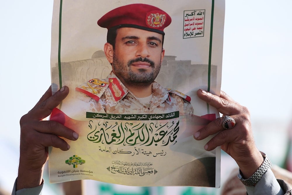 An Ansar Allah supporter holds a poster of Maj. Gen. Muhammad Abdul Karim al-Ghamari, who died of wounds he suffered after an Israeli attack, during an anti-US, anti-'Israel' rally in Sanaa, Yemen, Friday, Oct. 17, 2025 (AP)