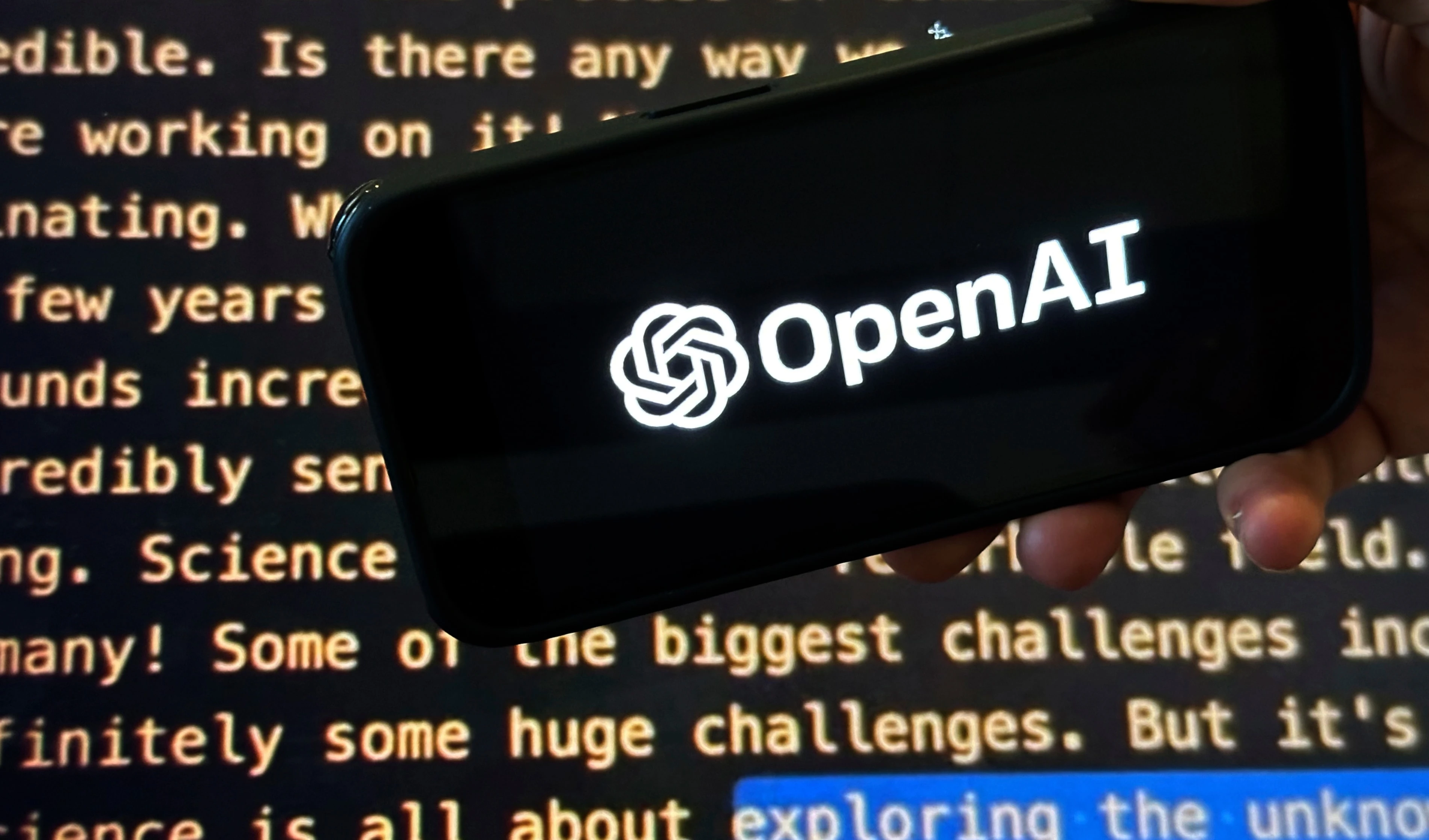 The OpenAI logo appears on a mobile phone in front of a screen showing part of the company website in this photo taken on Nov. 21, 2023 (AP) The OpenAI logo appears on a mobile phone in front of a screen showing part of the company website in this photo taken on Nov. 21, 2023 (AP)