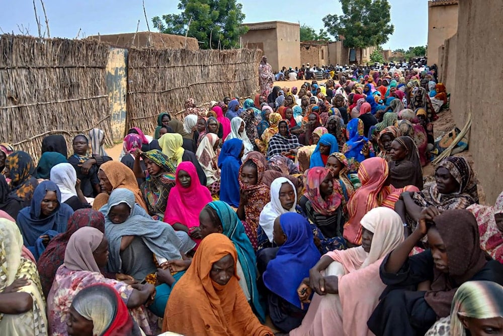 People gather to wait for food aid in El Fasher, the last city in the western Darfur region still held by the Sudanese army, and under constant attack from the RSF (AFP)