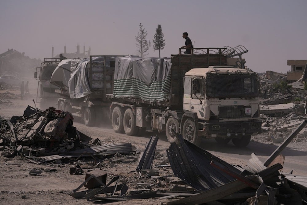 Trucks carrying humanitarian aid drive through Khan Younis, in the southern Gaza Strip, Monday, October 20, 2025. (AP Photo/Jehad Alshrafi)