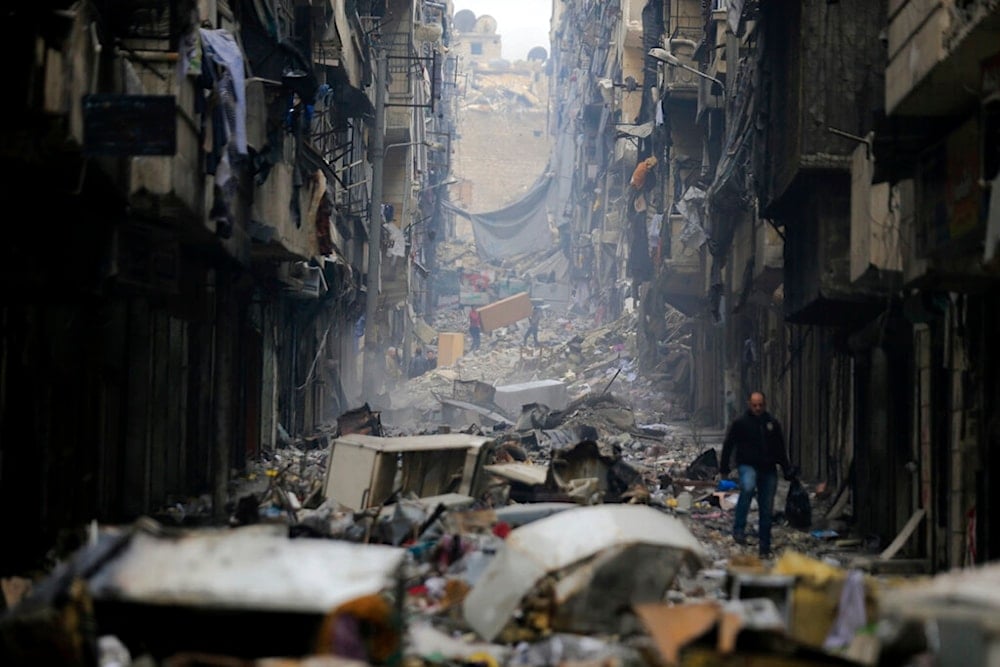 Residents walk through the destruction of the Salaheddine neighborhood in the eastern Aleppo, Syria, Friday, January 20, 2017 (AP)