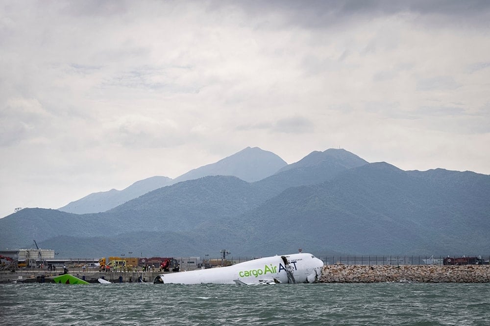 The cargo aircraft that skidded off a Hong Kong airport runway is seen on Monday, October 20, 2025. (AP Photo/Chan Long Hei)
