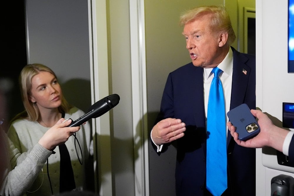 President Donald Trump speaks with reporters as White House press secretary Karoline Leavitt listens aboard Air Force One at Al Udeid Air Base in Doha, Qatar, Saturday, October 25, 2025. (AP Photo/Mark Schiefelbein)