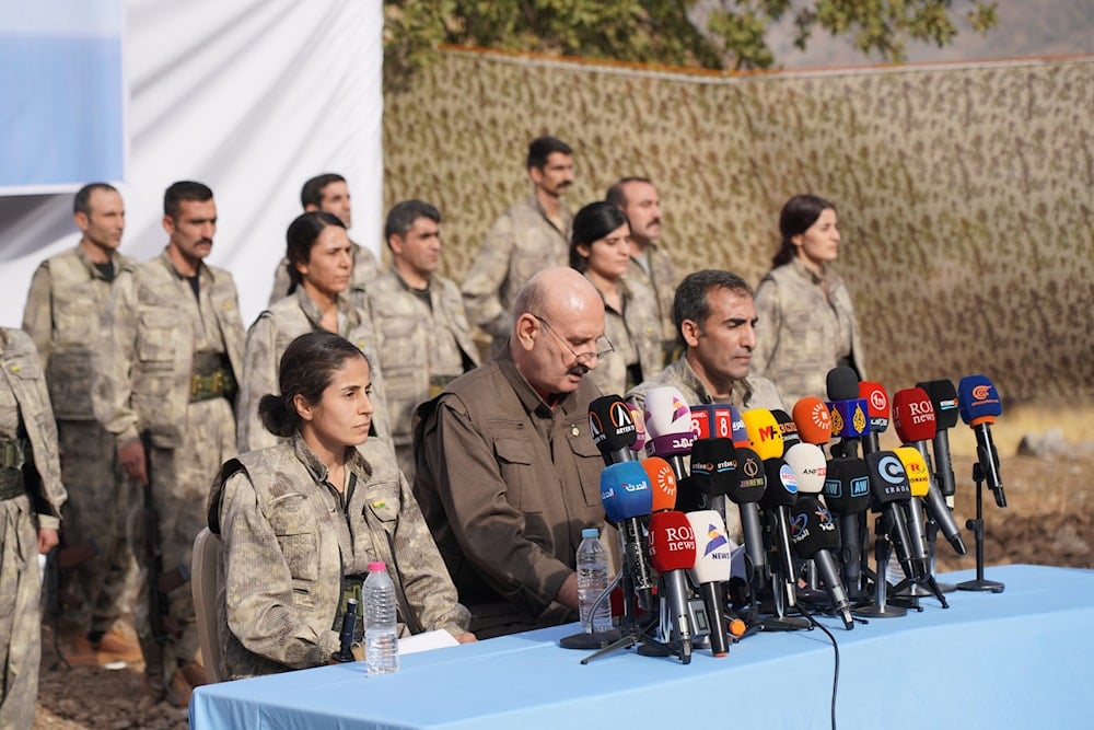 Kurdistan Workers' Party (PKK) fighters, who reportedly withdrew from Turkey with their weapons, stand to attention during a ceremony in the Qandil area of northern, Iraq, Sunday, Oct 26, 2025 (AP)