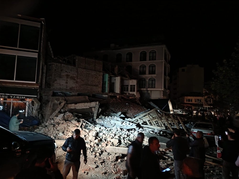 Residents gather amid the rubble of a collapsed building in Sindirgi, western Turkey, after a 6.1-magnitude earthquake struck late Monday night. (Agencies)