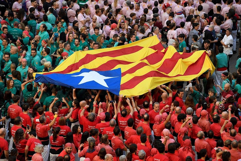 Teams members hold a Catalan pro-independence Estelada flag during the 28th edition of the 'human towers' competetion at the Tarraco arena in Tarragona on October 2, 2022 (Josep Lago/AFP via Getty Images)