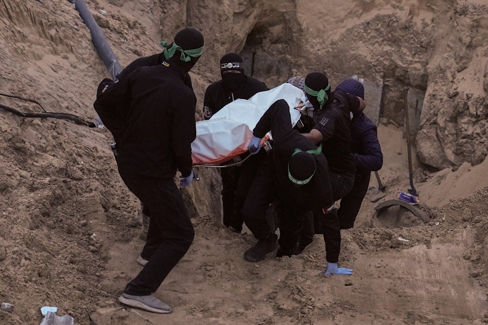 Al-Qassam Brigades fighters carry a white bag believed to contain a body, retrieved from a tunnel during a search for the remains of Israeli captives in Hamad City, Khan Younis, southern Gaza, Tuesday, Oct. 28, 2025 (AP)