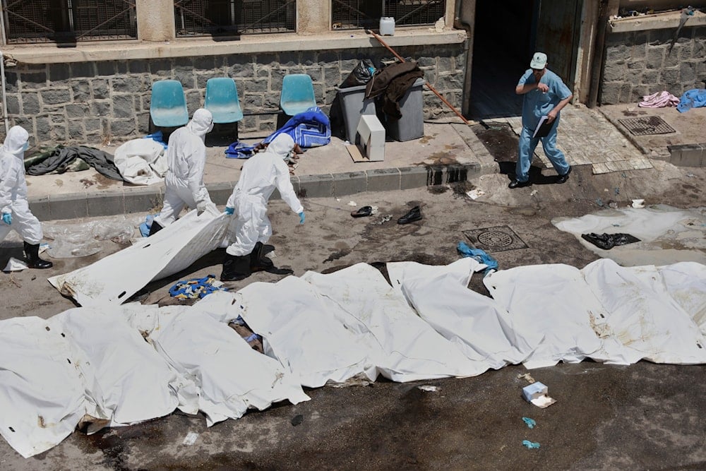 Morgue workers place the bodies of unidentified people killed during clashes between Bedouin clans and Druze militias, into plastic bags outside the National Hospital in Sweida, Syria, Monday, July 21, 2025 (AP)