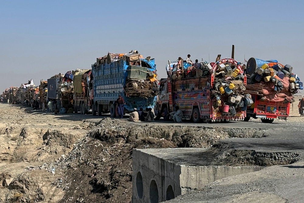Afghan refugees sit beside trucks as they wait their turn to leave for their homeland through a border crossing point which partially opens following Oct.19 ceasefire, on the outskirts of Chaman, Wednesday, Oct. 29, 2025 (AP)