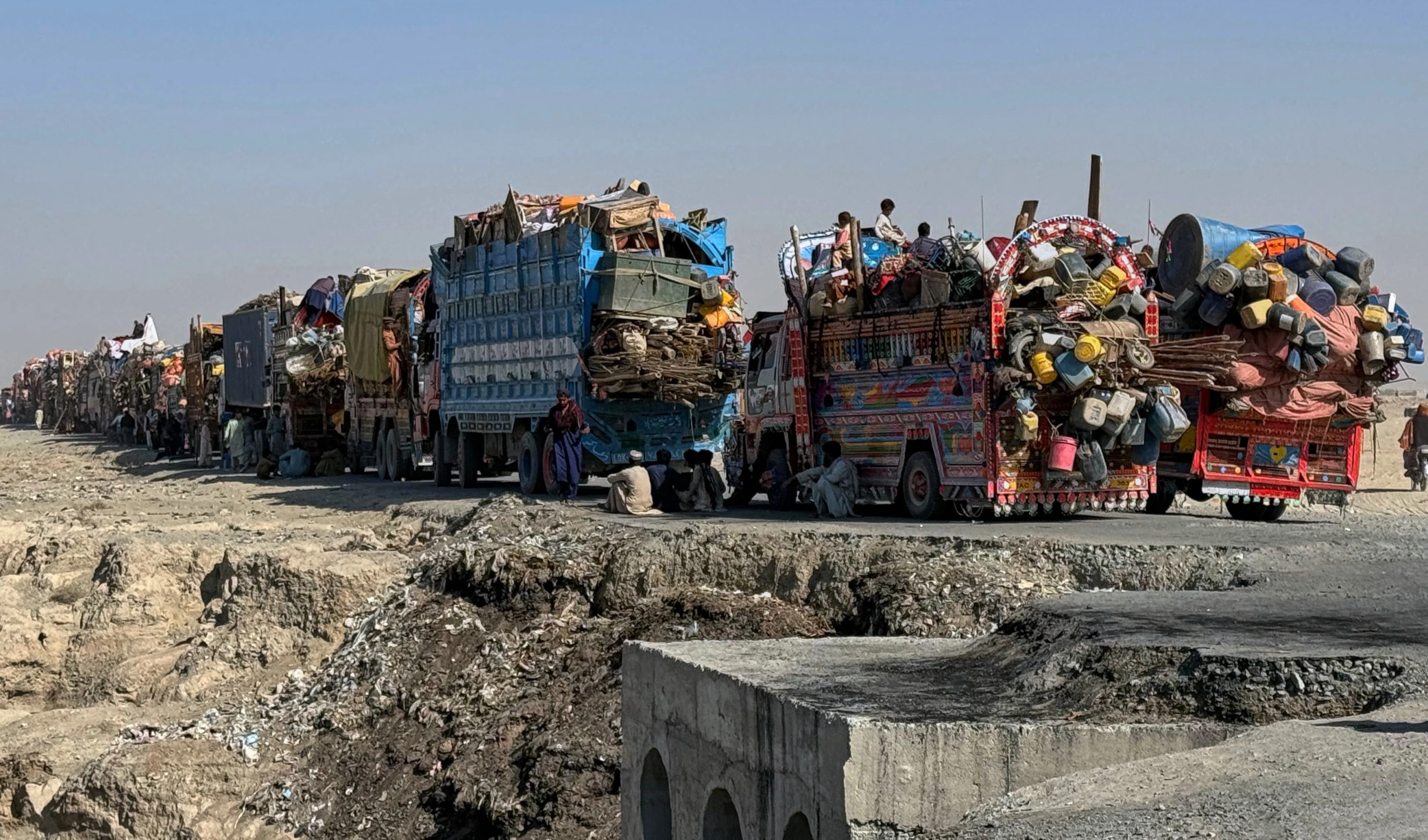 Afghan refugees sit beside trucks as they wait their turn to leave for their homeland through a border crossing point which partially opens following Oct.19 ceasefire, on the outskirts of Chaman, Wednesday, Oct. 29, 2025 (AP) Afghan refugees sit beside trucks as they wait their turn to leave for their homeland through a border crossing point which partially opens following Oct.19 ceasefire, on the outskirts of Chaman, Wednesday, Oct. 29, 2025 (AP)