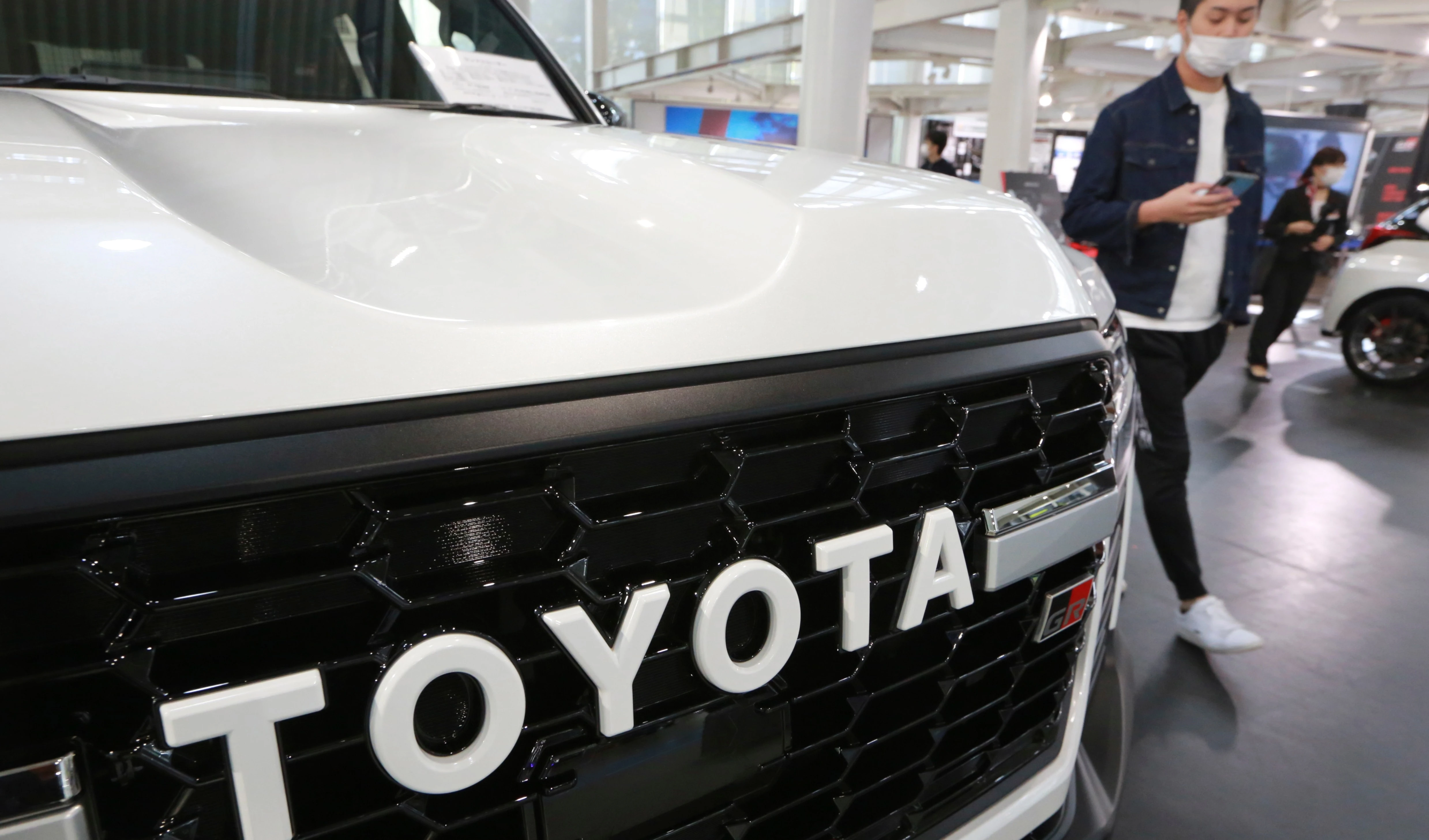 A man walks by the logo on a Toyota car at a showroom in Tokyo on Oct. 18, 2021. The shortage of parts caused by the coronavirus pandemic is further denting production at Toyota, Japan’s top automaker. (AP Photo/Koji Sasahara, File) A man walks by the logo on a Toyota car at a showroom in Tokyo on Oct. 18, 2021. The shortage of parts caused by the coronavirus pandemic is further denting production at Toyota, Japan’s top automaker. (AP Photo/Koji Sasahara, File)