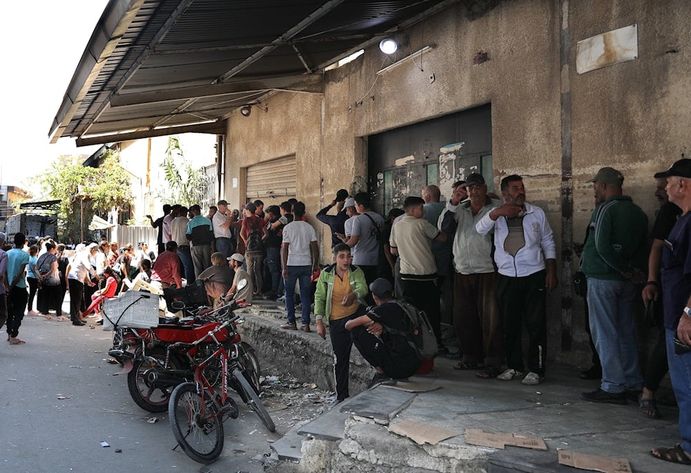 People line up for bread outside a bakery in Sweida, southern Syria, on Sept. 18, 2025 (AP)