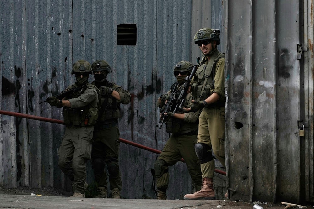 Members of Israeli security forces stand in guard on an alley during a military raid in the West Bank city of Nablus, Wednesday, Aug. 27, 2025 (AP)