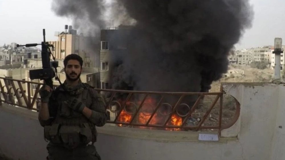 This undated picture shows Israeli trooper Tameer Mulla posing with destruction in Gaza during Tel Aviv’s October 2023-present war of genocide on the Gaza Strip.