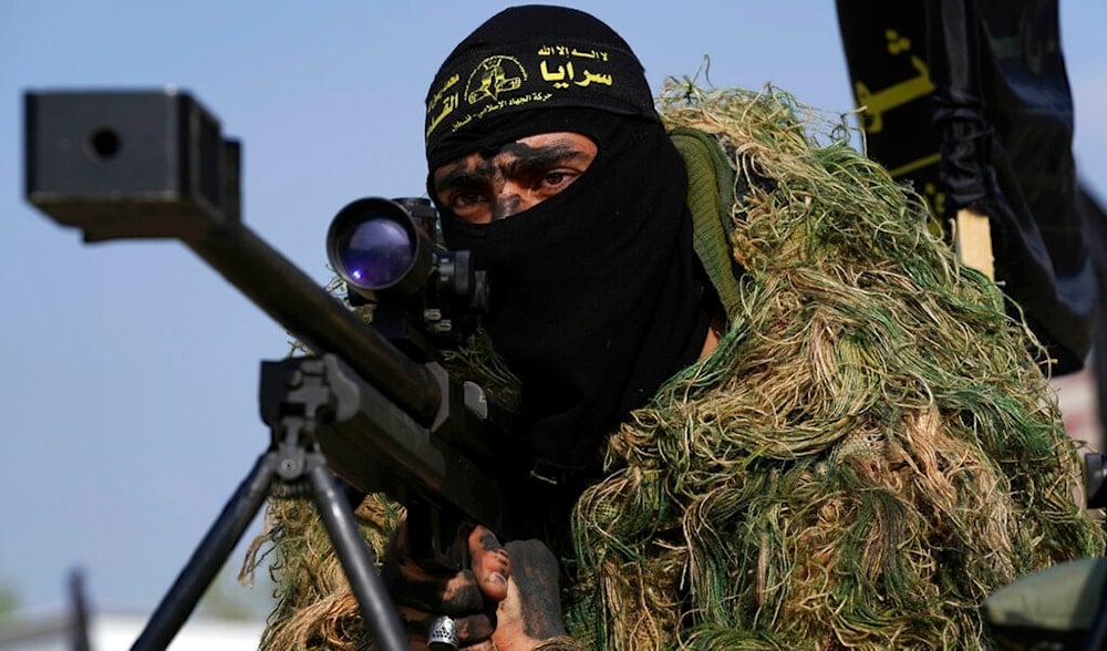 Masked member of the Palestinian Al-Quds Brigades sitting behind sniper rifles during a rally to commemorate the 35th anniversary of their group in Nuseirat refugee camp, central Gaza Strip, Oct. 4, 2022. (AP)