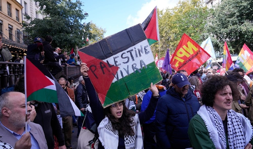 A demonstrator holds a placard that reads, 