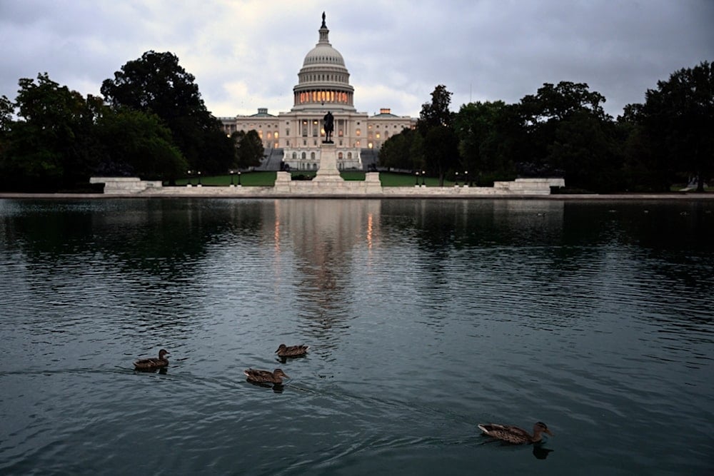 Ducks swim at daybreak in the US Capitol Reflecting Pool during the 8th day of the government shutdown on Wednesday, October 8, 2025, in Washington (AP)