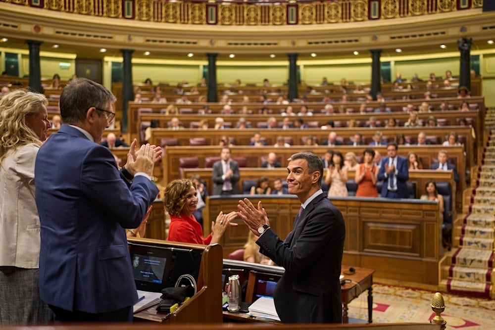 Spanish Prime Minister Pedro Sánchez, right, applauds after delivering a speech at the Spanish parliament in Madrid, Wednesday, July 9, 2025. (AP Photo/Bernat Armangue)