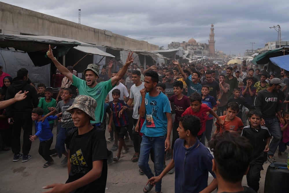 Palestinians celebrate following the announcement that Israel and Hamas have agreed to the first phase of a peace plan to pause the fighting, in Khan Younis, southern Gaza Strip, Thursday, Oct. 9, 2025 (AP)