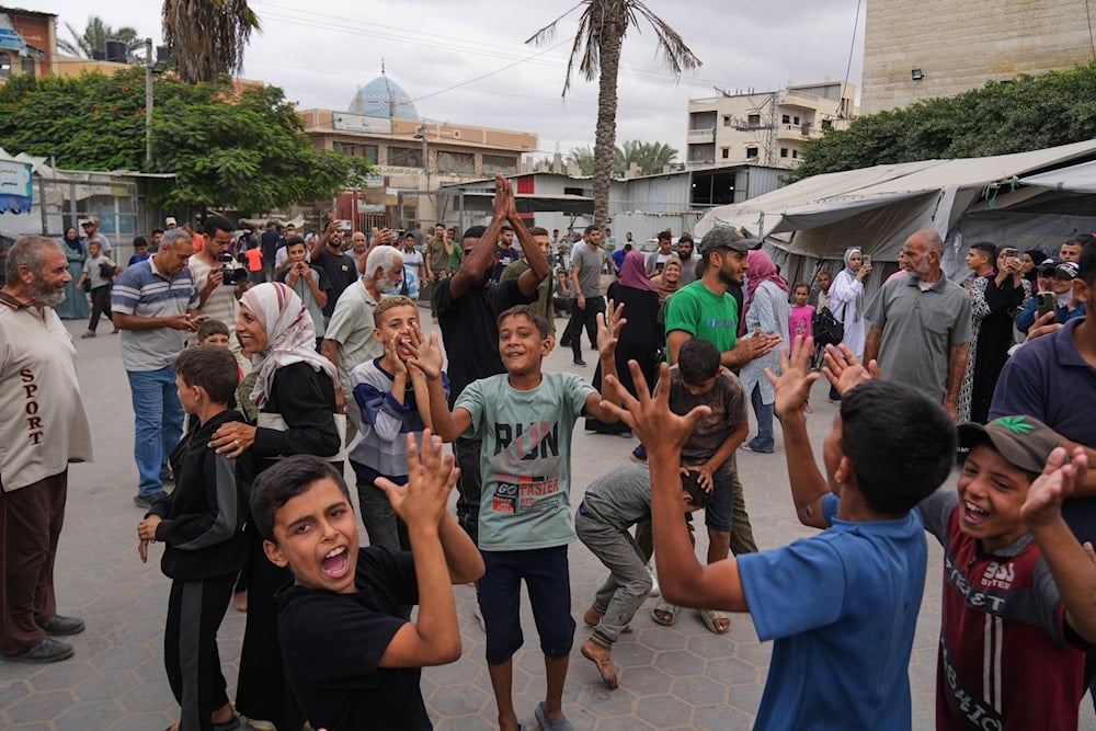 Palestinians celebrate following the announcement that Israel and Hamas have agreed to the first phase of a peace plan to pause the fighting, outside Al-Aqsa Hospital in Deir al-Balah, central Gaza Strip, Thursday, Oct. 9, 2025 (AP)