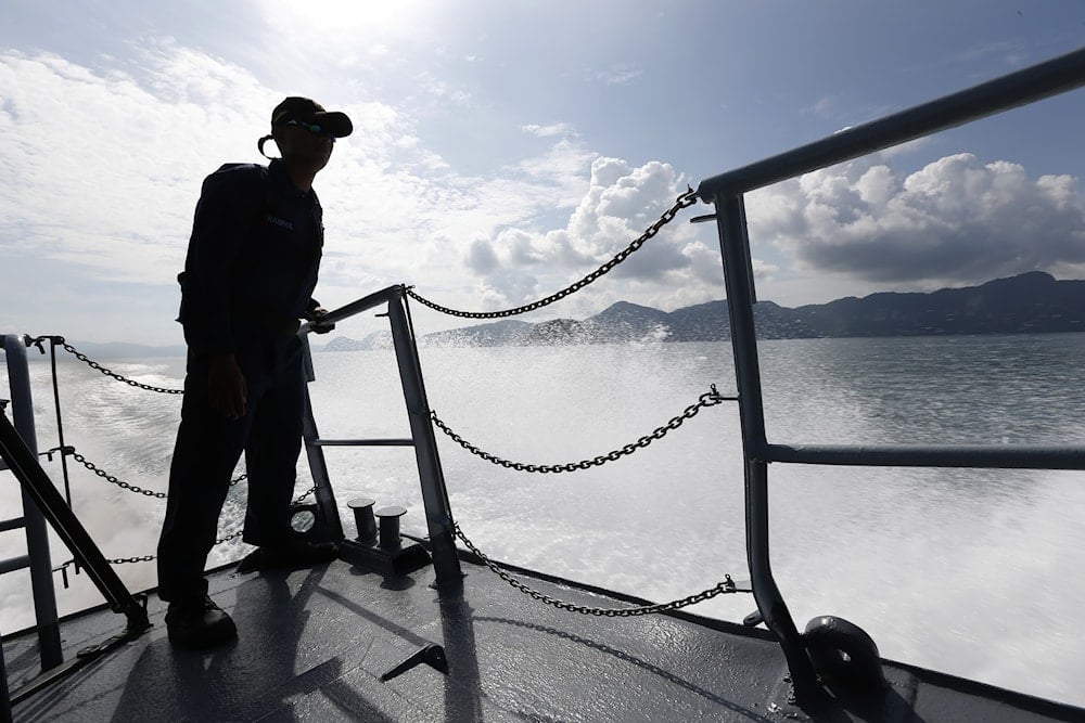 A member of Malaysian Navy is silhouetted as he stands guard on the bow of a corvette ship during a media trip for the search and rescue mission of Rohingya migrants in Langkawi, Malaysia on May 28, 2015. (AP)
