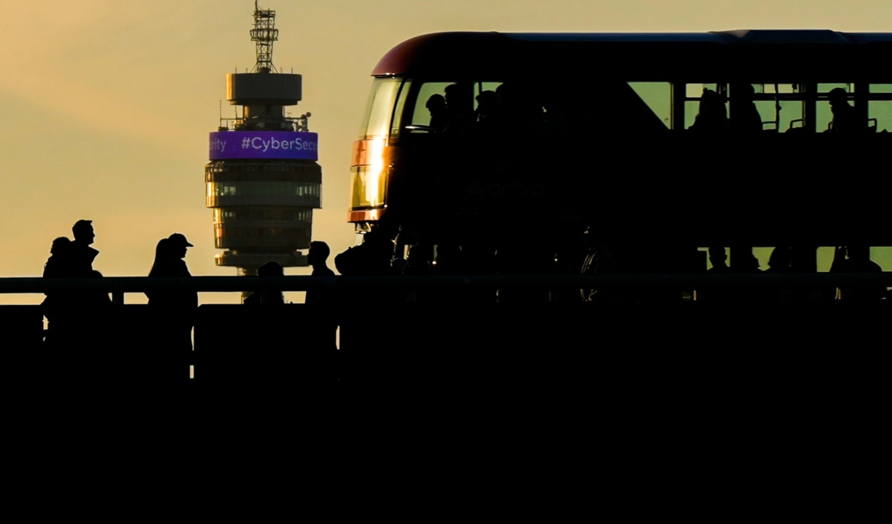 People walk and a red double-decker bus drives on the London Bridge during evening rush hour as BT Tower is seen in the background, on October 6, 2025, in London. (AP Photo/Julia Demaree Nikhinson)
