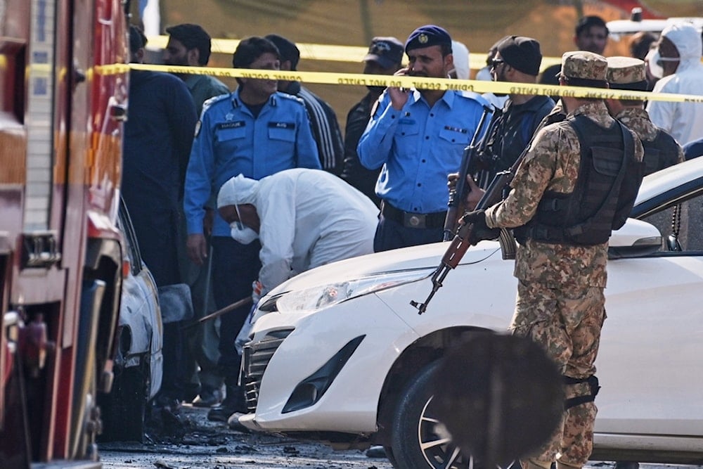 Pakistani investigators examine a damage car at the site of a suicide bombing outside the gates of a district court, in Islamabad, Pakistan, Tuesday, Nov. 11, 2025. (AP Photo/Ahsan Shahzad)