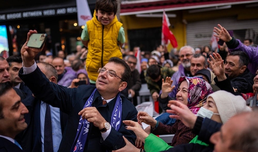 Istanbul Mayor and Republican People's Party, or CHP, candidate Ekrem Imamoglu take photographs with supporters during a campaign rally in Istanbul, Turkey, March 21, 2024.(AP)