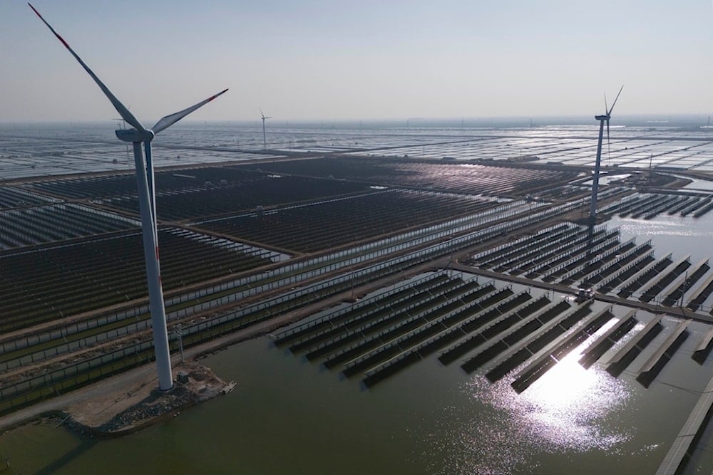 Wind turbines dot the coastline along a giant solar farm near Weifang in eastern China's Shandong province on March 22, 2024. (AP Photo/Ng Han Guan)