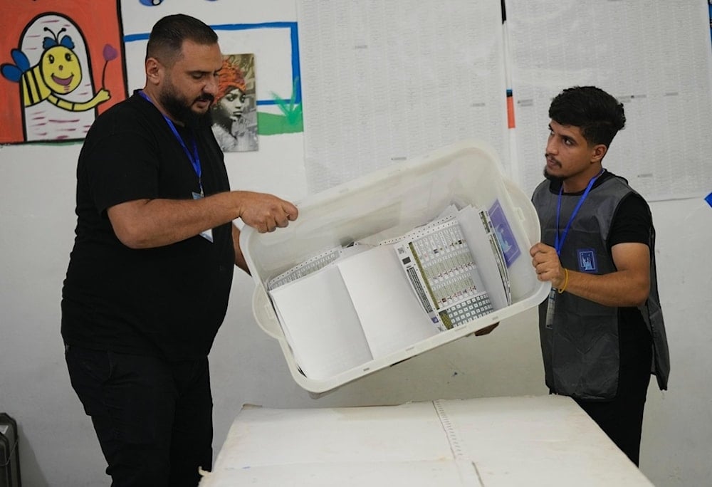 Election workers opens a ballot box after the polls closed in Baghdad, Iraq, Tuesday, November 11, 2025 (AP)