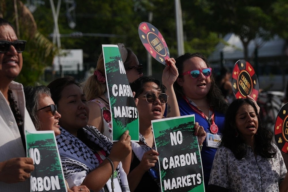Demonstrators protest against carbon markets outside the venue for the COP30 U.N. Climate Summit, Tuesday, Nov. 11, 2025, in Belem, Brazil. (AP Photo/Fernando Llano)