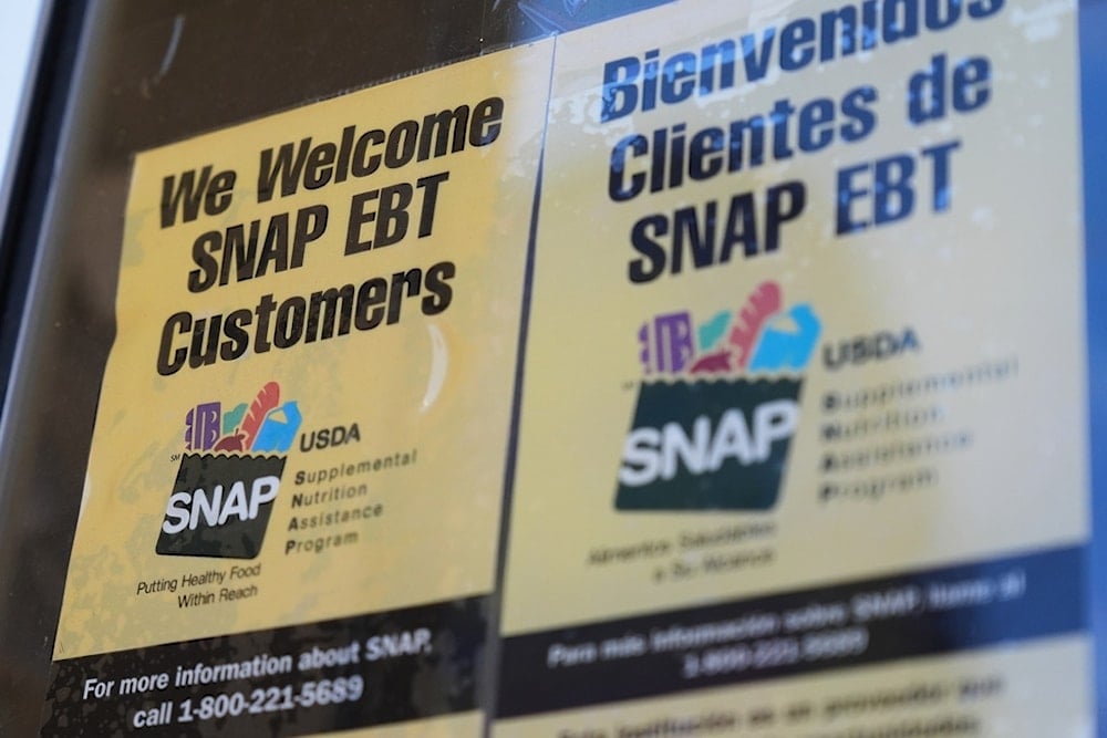 A SNAP EBT information sign is displayed outside of a convenience store in Baltimore, Monday, November 10, 2025. (AP Photo/Stephanie Scarbrough)