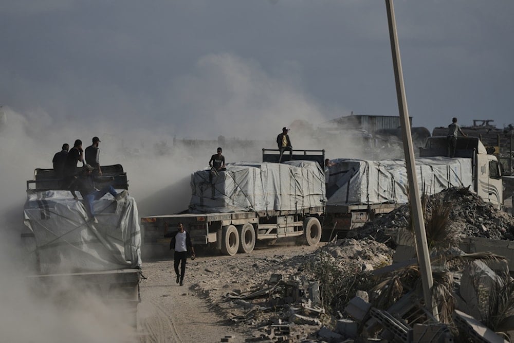 Trucks carrying humanitarian aid drive through Gaza City after entering via the Zikim crossing, northern Gaza Strip, Thursday, November 13, 2025 (AP)
