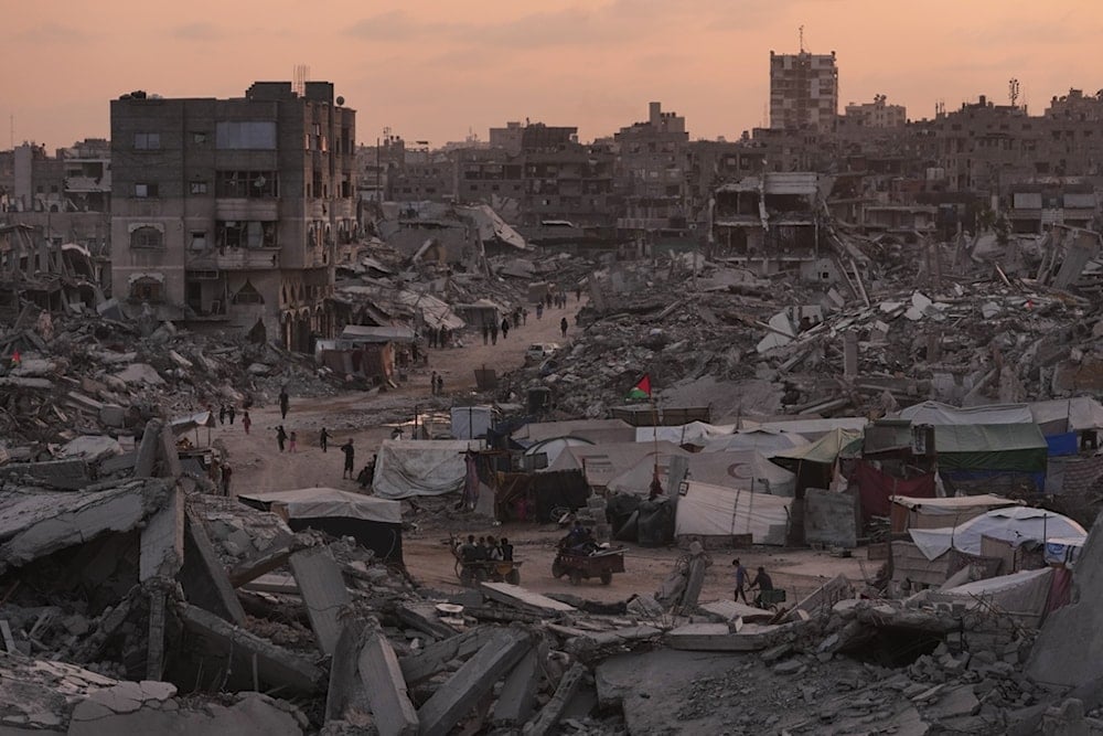 Palestinians walk through the destruction caused by the Israeli air and ground offensive in Sheikh Radwan neighborhood in Gaza City, Tuesday, Nov. 11, 2025 (AP)