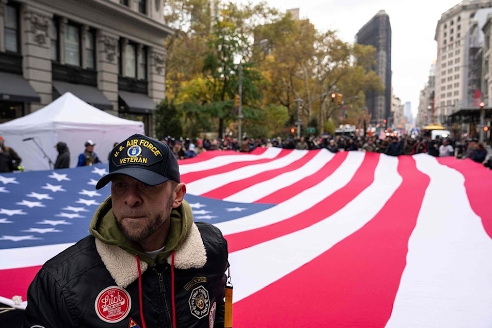 A U.S. Air Force veteran holds an American flag during the Veterans Day parade, Tuesday, Nov. 11, 2025, in New York. (AP Photo/Yuki Iwamura)