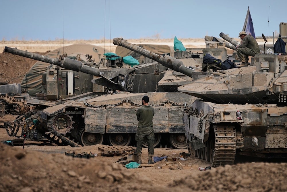 Israeli soldiers work on tanks at a staging area on the border with Gaza Strip, Occupied Palestine, Wednesday, Oct. 29, 2025 (AP)