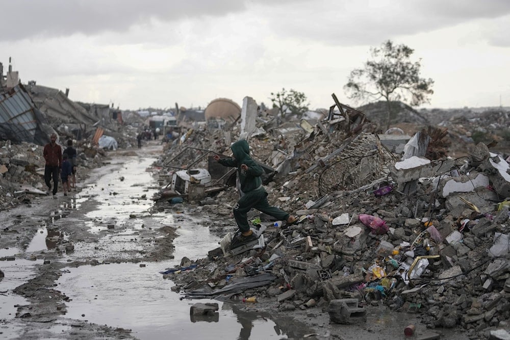 A Palestinian child walks through the rain in the Sheikh Radwan neighborhood of Gaza City, Friday, Nov. 14, 2025 (AP)