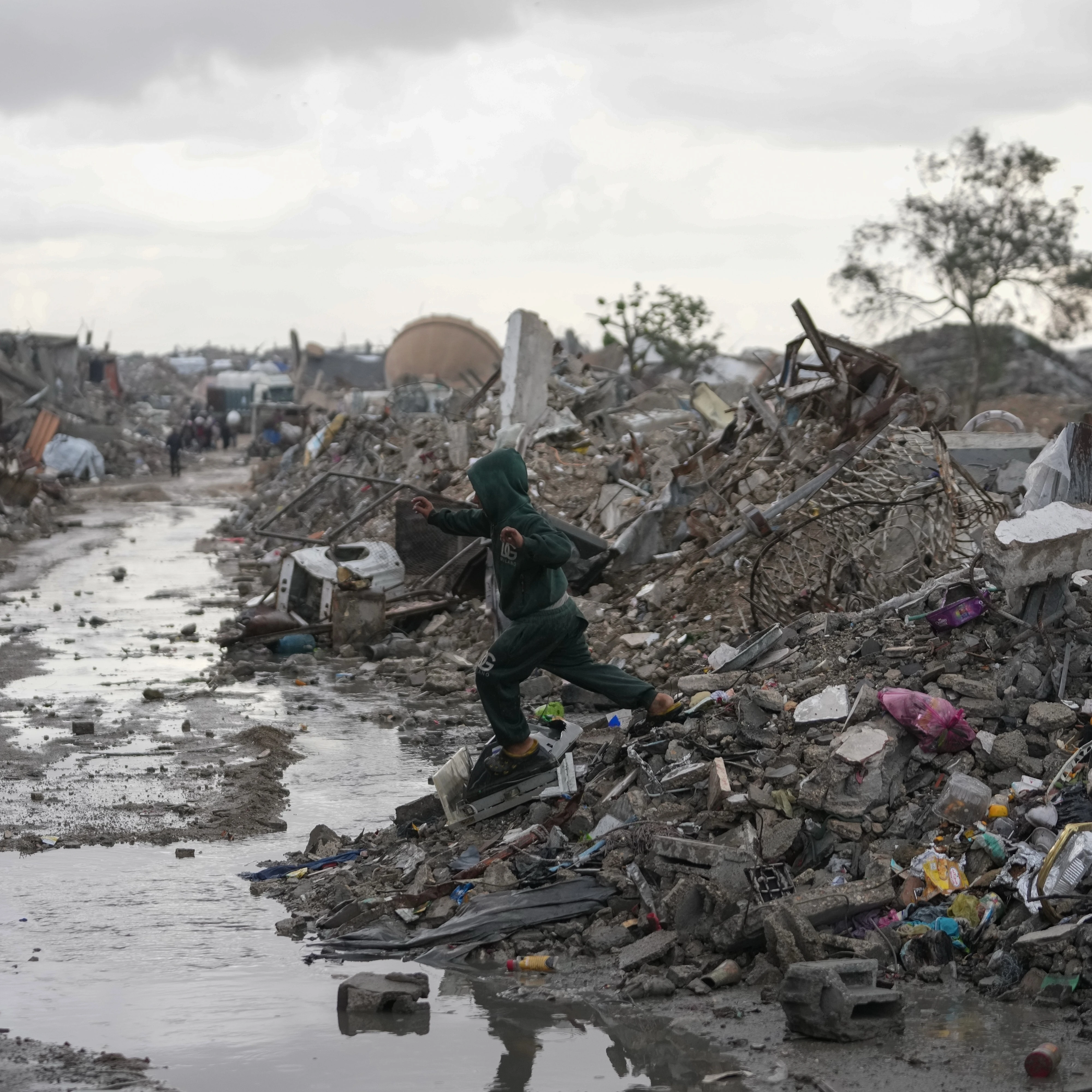 A Palestinian child walks through the rain in the Sheikh Radwan neighborhood of Gaza City, Friday, Nov. 14, 2025 (AP)