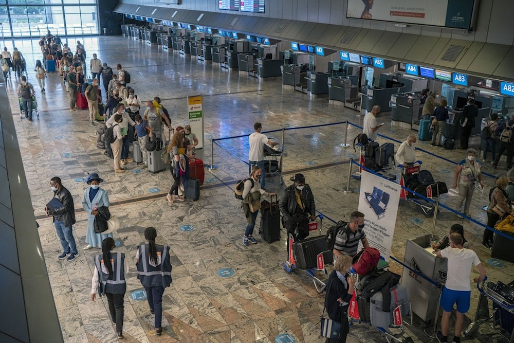 Passengers check in at a counter at Johannesburg's OR Tambo International Airport, South Africa, November 29, 2021. (AP Photo)