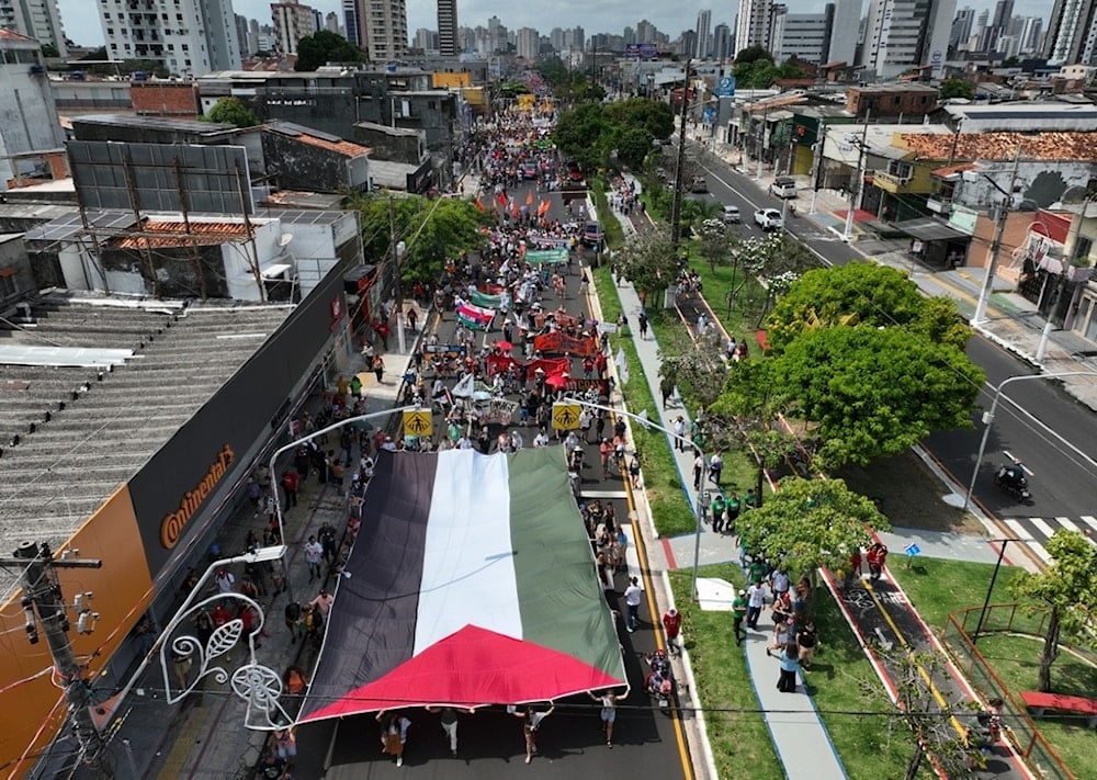 Activists participate in a climate protest, some holding a Palestinian flag, during the COP30 U.N. Climate Summit, Saturday, November 15, 2025, in Belem, Brazil. (AP Photo/Andre Penner)