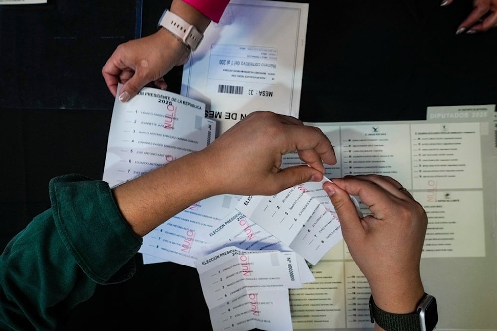 An electoral worker prepares demonstration ballots inside the old Mapocho train station that is now a cultural center to be used as a polling station for the general election in Santiago, Chile, Friday, November 14, 2025. (AP Photo/Esteban Felix)