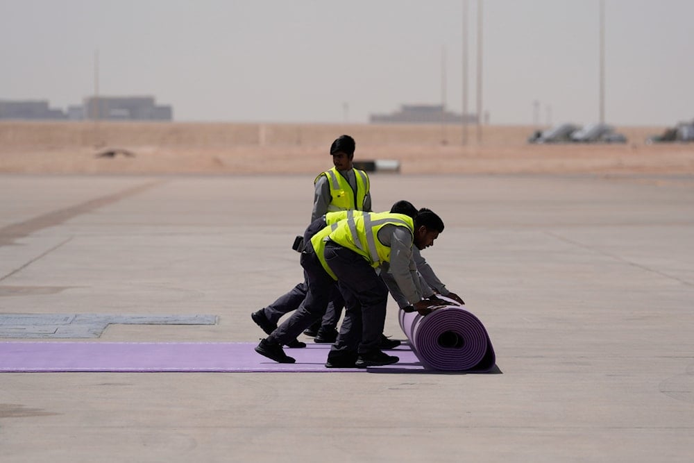 Workers roll the red carpet as President Donald Trump arrives on Air Force One at King Khalid International Airport Royal Terminal in Riyadh, Saudi Arabia, Tuesday, May 13, 2025 (AP)